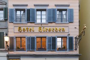 a building with blue shutters and a sign on it at Hotel Hirschen in Zürich