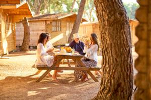 a group of people sitting at a picnic table at Camping Escana in Es Cana