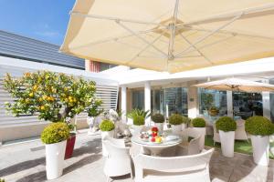 eine Terrasse mit einem Tisch, Stühlen und einem Sonnenschirm in der Unterkunft JC Hotel in Rom