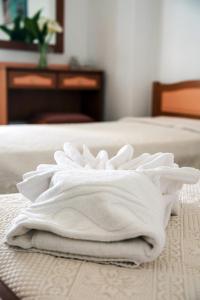 a stack of white towels sitting on a bed at Contaratos Holiday Lettings 3 in Livadi