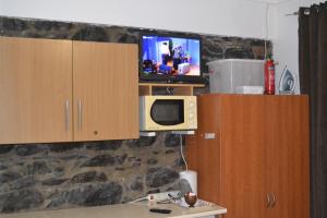 フンシャルにあるCentral Suite in Funchal 2Nのキッチン(電子レンジ、壁掛けテレビ付)