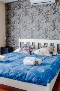Una cama con sábanas azules y toallas. en Milano Urban Penthouse, en Milán