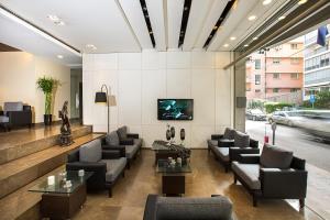 a lobby with couches and a tv on a wall at Orient Queen Homes Hotel in Beirut