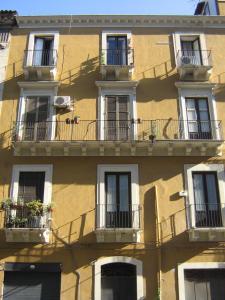 un edificio amarillo con balcones y ventanas. en Solsicily, en Catania