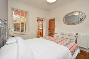 a white bedroom with a large bed and a mirror at The LOCATION- 1 FREE PRIVATE PARKING SPACE - 60 SECOND WALK 2 MINSTER! in York
