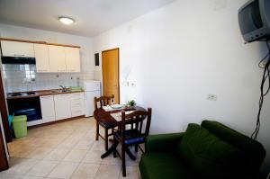 ein Wohnzimmer mit einem Tisch und einer Küche in der Unterkunft Apartments Ida Cres in Cres