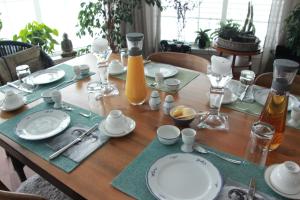 una mesa de madera con platos y utensilios. en Solheim Fritidsgård, en Svensby