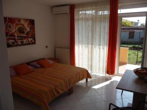 a bedroom with a bed and a large window at Apartments Milka in Umag