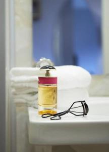 a bottle of oil and a pair of glasses on a sink at Hotel Surte in Surte
