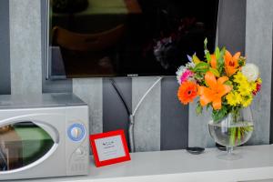 a vase of flowers sitting next to a microwave at Milano Urban Penthouse in Milan