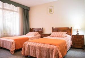 a hotel room with two beds and a window at GHL casa hotel in Bogotá