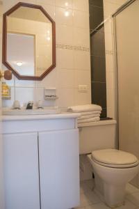 a bathroom with a toilet and a sink and a mirror at GHL casa hotel in Bogotá