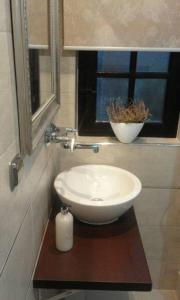 La salle de bains est pourvue d'un lavabo blanc et d'une fenêtre. dans l'établissement Wałpusz Holiday Home, à Szczytno