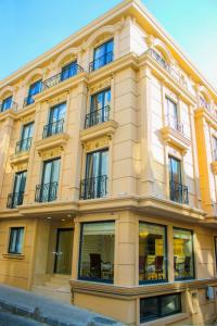 - un grand bâtiment jaune avec des fenêtres et des balcons dans l'établissement Deluxe Newport Hotel, à Istanbul