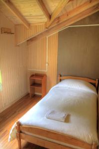 Cama en habitación con techo de madera en Turismo Rural Los Alpes en Futaleufú