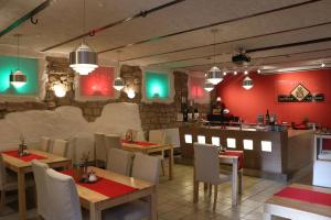 un restaurante con mesas, sillas y paredes rojas en Hotel & Restaurant Weisenheimer Hof, en Weisenheim am Berg