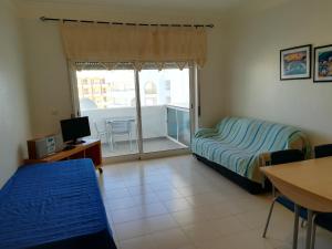 
a living room with a bed and a table at Apartamento Varandas do Sol Nascente in Porches

