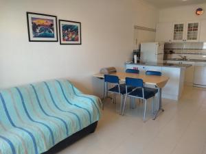 
a kitchen with a table and chairs and a refrigerator at Apartamento Varandas do Sol Nascente in Porches
