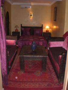 1 dormitorio con 2 camas, mesa y sofá en Riad Hiba en Marrakech