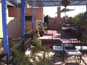 un patio al aire libre con mesas, sillas y plantas en Riad Hiba en Marrakech