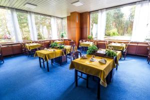 a dining room with tables with yellow table cloth at Hotel Bezdez Stare Splavy in Staré Splavy