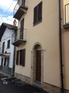 a building with a door and a balcony at Appartamento Riva in Neive