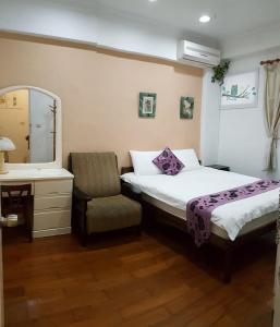 - une chambre avec un lit, une chaise et un miroir dans l'établissement Dongshan River Left Bank, à Wujie