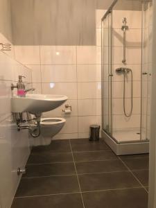 a bathroom with a toilet and a sink and a shower at Hotel-Restaurant Haus Nattkemper in Hamm +144 photos