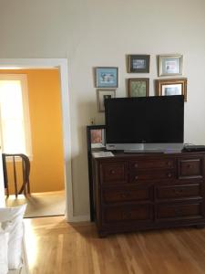a living room with a television on a dresser at SWEET Suite BAKER Street in San Francisco