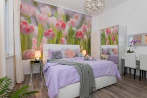 a bedroom with a bed with pink flowers on the wall at Guest house Lenny rooms in Zadar