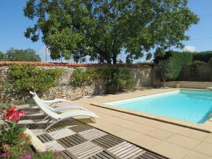 Saint-Aubin-la-Plaine的住宿－勞比諾斯住宿加早餐旅館，一把椅子和一个游泳池