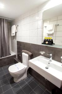 a bathroom with a toilet and a sink at Hotel Lithaion in Tr&iacute;kala