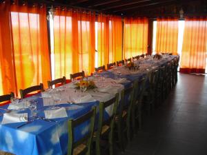 una mesa larga con mesas azules y sillas en una habitación en Agriturismo Costa San Bernardo en Vaglio di Basilicata