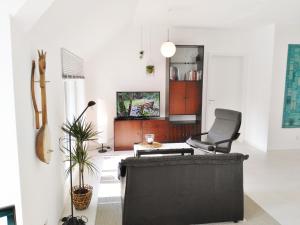 a living room with a black couch and a chair at FeWo WELL in Gladenbach