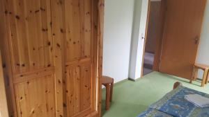 a bedroom with a wooden closet and a bed at Kapitänskoje in Breege