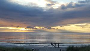 a sunset over a beach with the ocean at Kapitänskoje in Breege