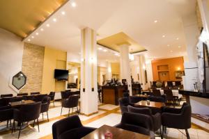 a restaurant with chairs and tables and a bar at Hotel Lithaion in Tr&iacute;kala