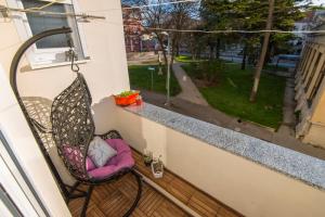 una mecedora en un balcón con vistas a una ventana en Guest house Lenny rooms en Zadar