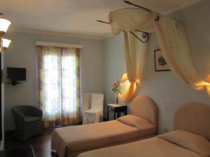 a bedroom with two beds and a window with curtains at Levant Hotel in Pelekas