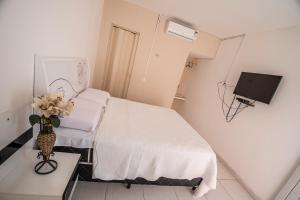 mały pokój z łóżkiem i telewizorem w obiekcie Pousada e Restaurante Manaím w mieście Passa e Fica