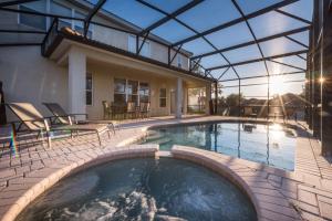 a swimming pool with a patio and a house at Beechfield Villa 7829 in Orlando