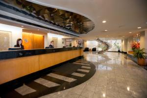 a lobby with two people sitting at a counter at Somerset Inn Troy in Troy