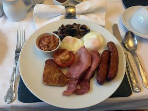 talerz jedzenia śniadaniowego z jajkami, fasolką bekonu i tostem w obiekcie Crickleigh House w mieście Llandudno