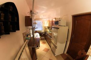 a small kitchen with a refrigerator and a microwave at Apartmanovy dom Cottage in Liptovský Ján