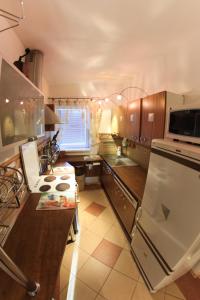 Il comprend une cuisine équipée d'un réfrigérateur blanc et d'un comptoir. dans l'établissement Apartmanovy dom Cottage, à Liptovský Ján