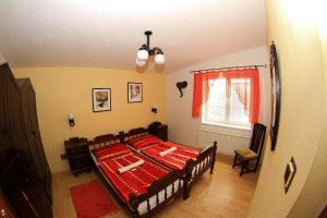 a bedroom with a red bed and a window at Apartmanovy dom Cottage in Liptovský Ján