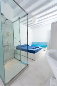 ミコノス・シティにあるMumua Studiosのベッドルーム1室(ベッド1台、シャワー、バスタブ付)