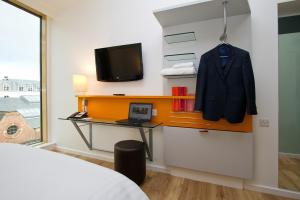 a room with a bed and a desk with a tv at Sleeperz Hotel Newcastle in Newcastle upon Tyne