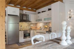 a kitchen with white cabinets and a table and chairs at Anapama in Fiskardo