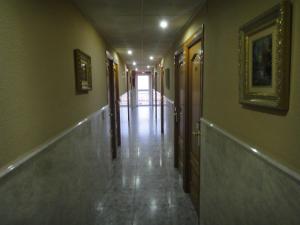 a hallway with a door leading to a hallway with a mirror at Hostal Real in Plasencia